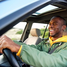 Man smiles while driving