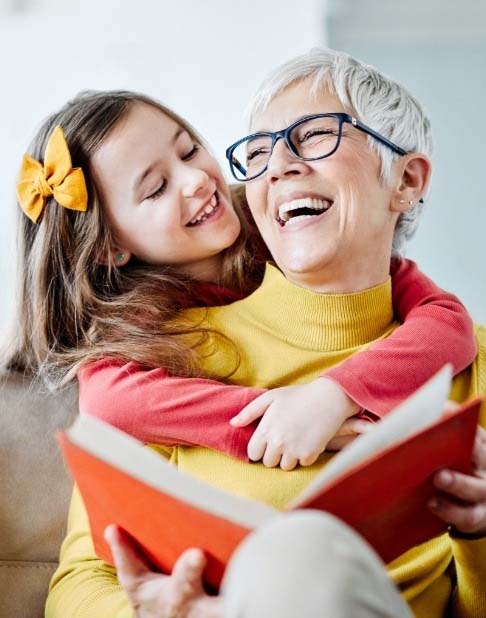 Grandmother smiling at granddaughter after smile makeover