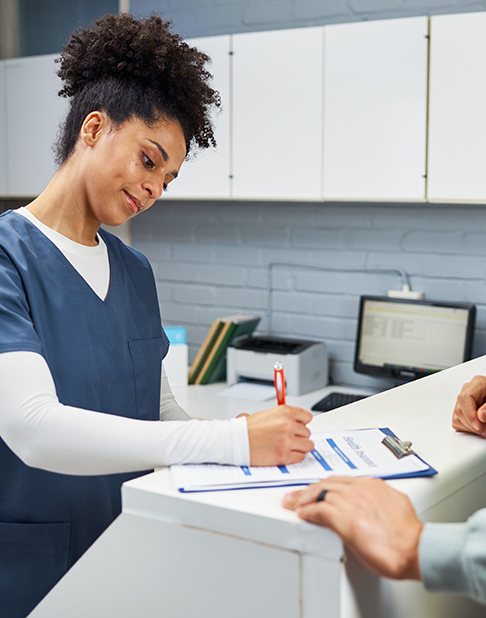 an insurance coordinator filling out forms for a patient