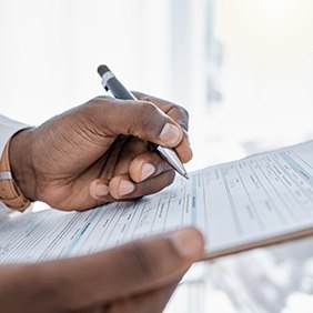 a patient filling out forms attached to a clipboard