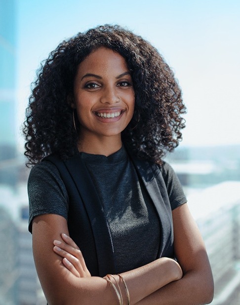 Woman with curly hair smiling in office building