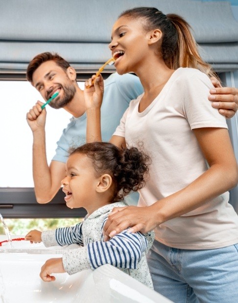 Family brushing teeth to prevent dental emergencies