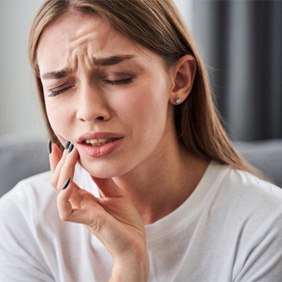 A woman suffering from a dental emergency