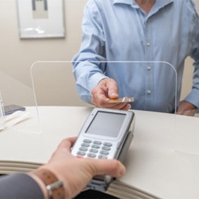 A patient paying the cost of emergency dentistry