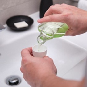 Closeup of patient pouring mouthwash into cap