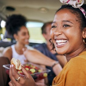 Smiling woman eating well-balanced meal on road trip