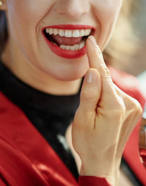 Woman pointing to tooth-colored filling in New York