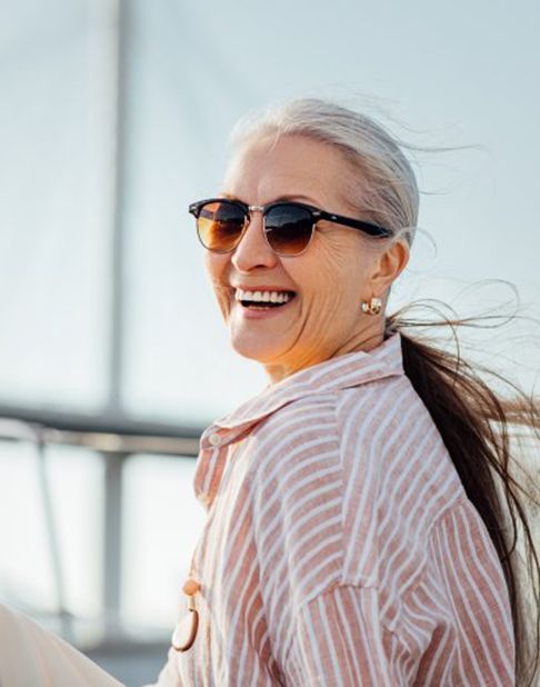 Woman smiling and enjoying the sea breeze on her boat