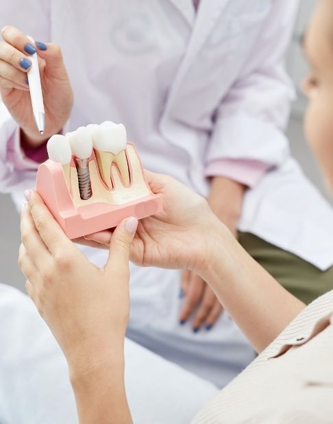 Dentist and patient discussing the four step dental implant process