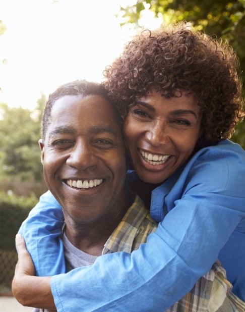 Man and woman enjoying the benefits of dental implants