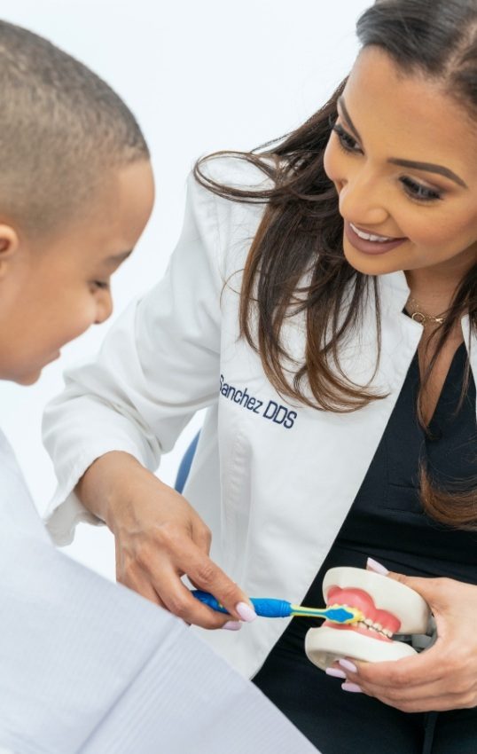 New York City dentist showing a patient how to brush their teeth