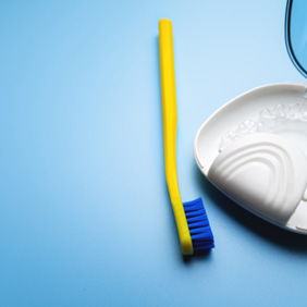 Toothbrush lying next to clear aligner in case