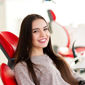 woman smiling while sitting in treatment chair