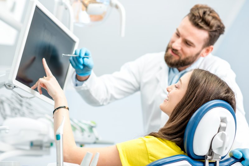 dentist showing patient dental X-rays