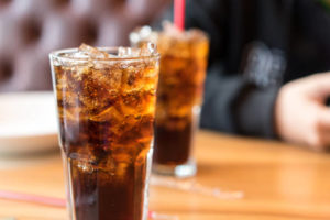 Two glasses of soda on a table