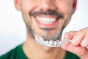 Man smiling after removing his Invisalign tray